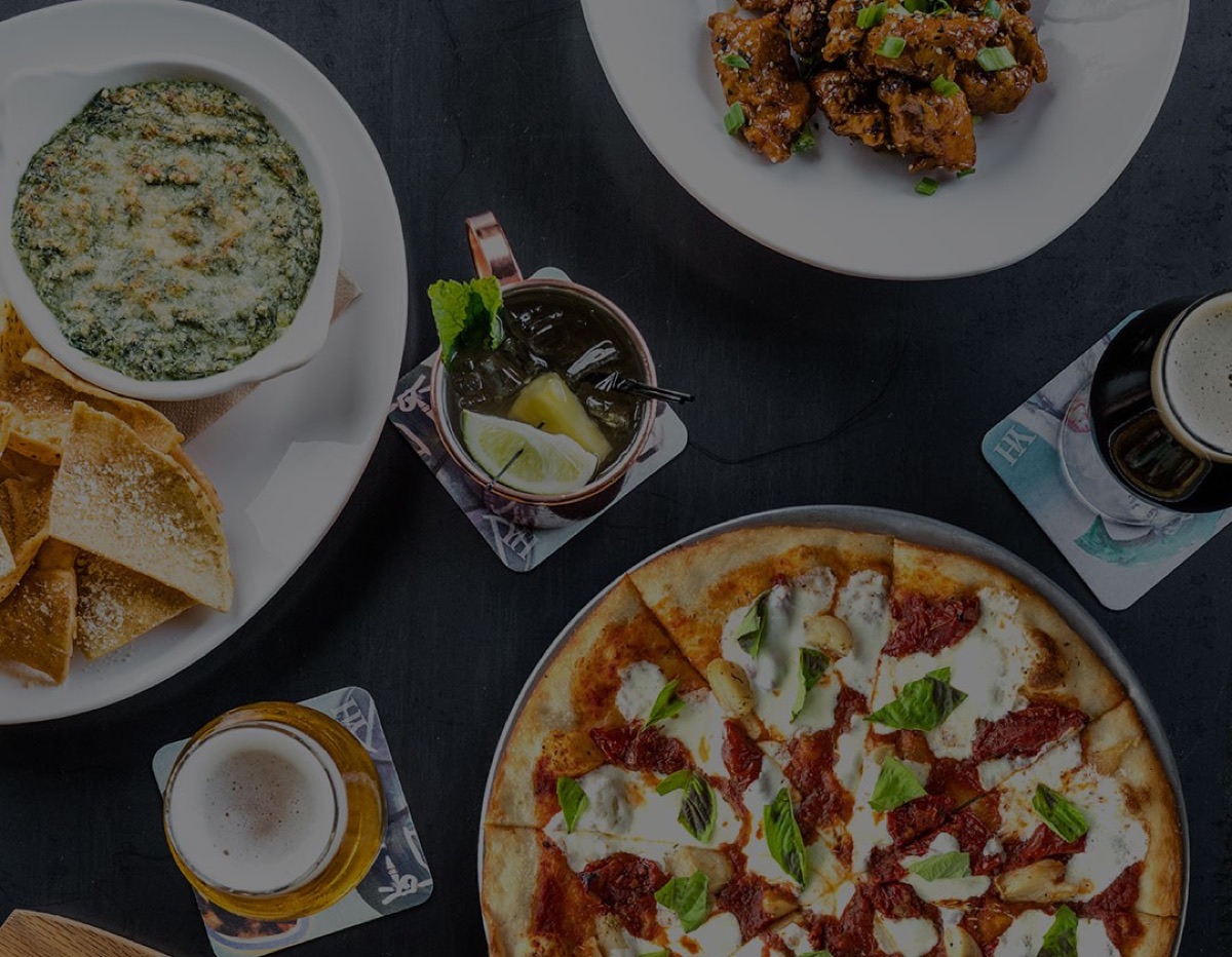 Pizza, spinach dip, wings and drinks on a table, Yard House