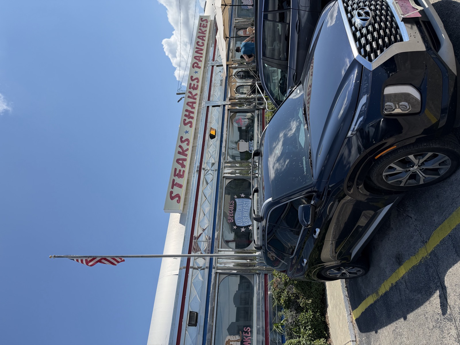 All American Diner's chrome exterior on Front Beach Road, with a Steaks Shakes Pancakes sign and an American flag out front