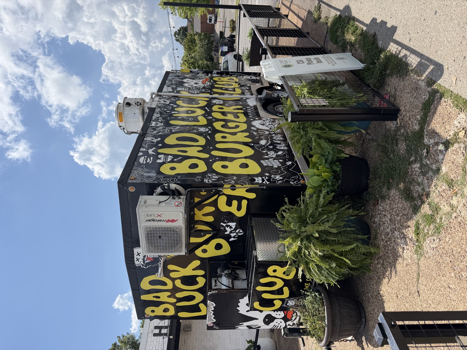 The Bad Luck Burger Club trailer in East Nashville, painted black with yellow lettering and cartoon cats