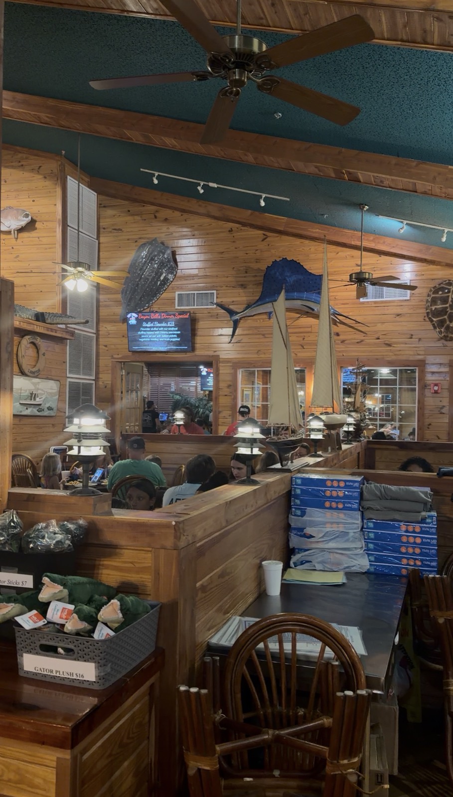 Inside Bayou Bill's Crab House, with wood-panelled walls, a mounted marlin and model sailboats above the booths