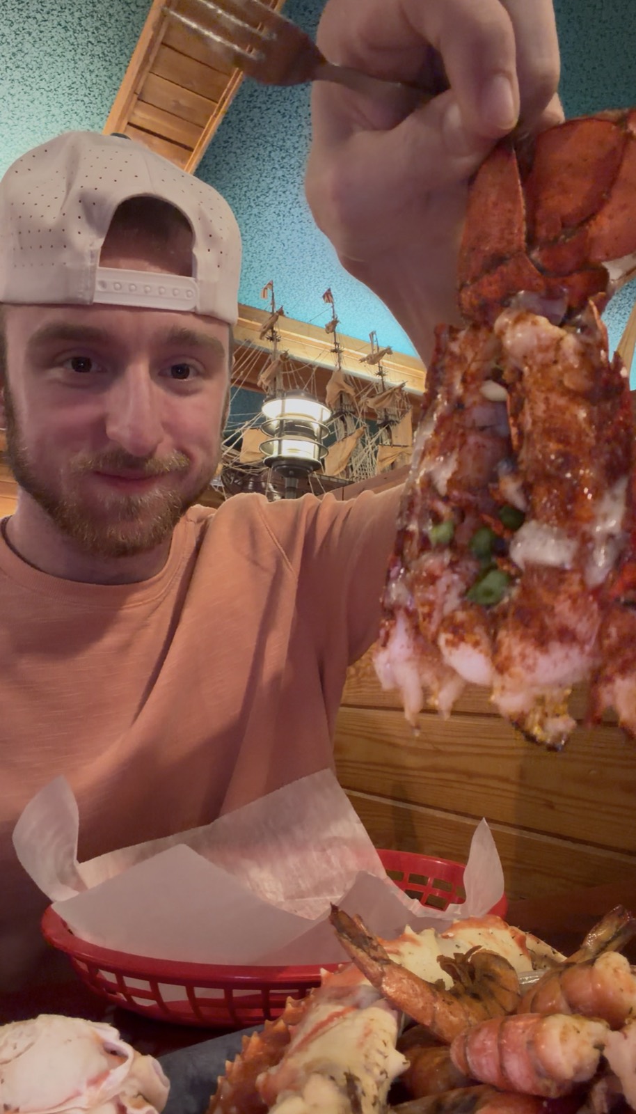 Sam holding up a cold water lobster tail from the Ultimate Feast for 2, Bayou Bill's Crab House