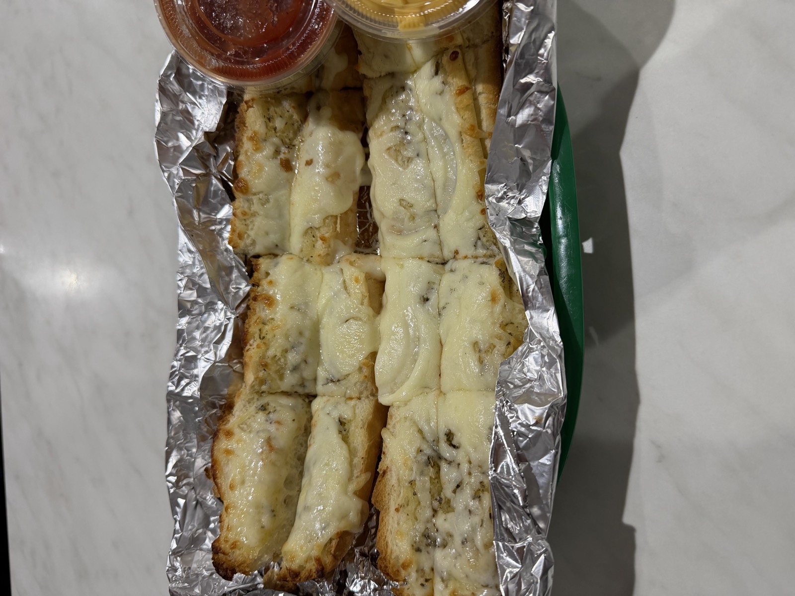 Sam's order: Garlic Cheesy Bread in foil with cups of marinara and cheese sauce