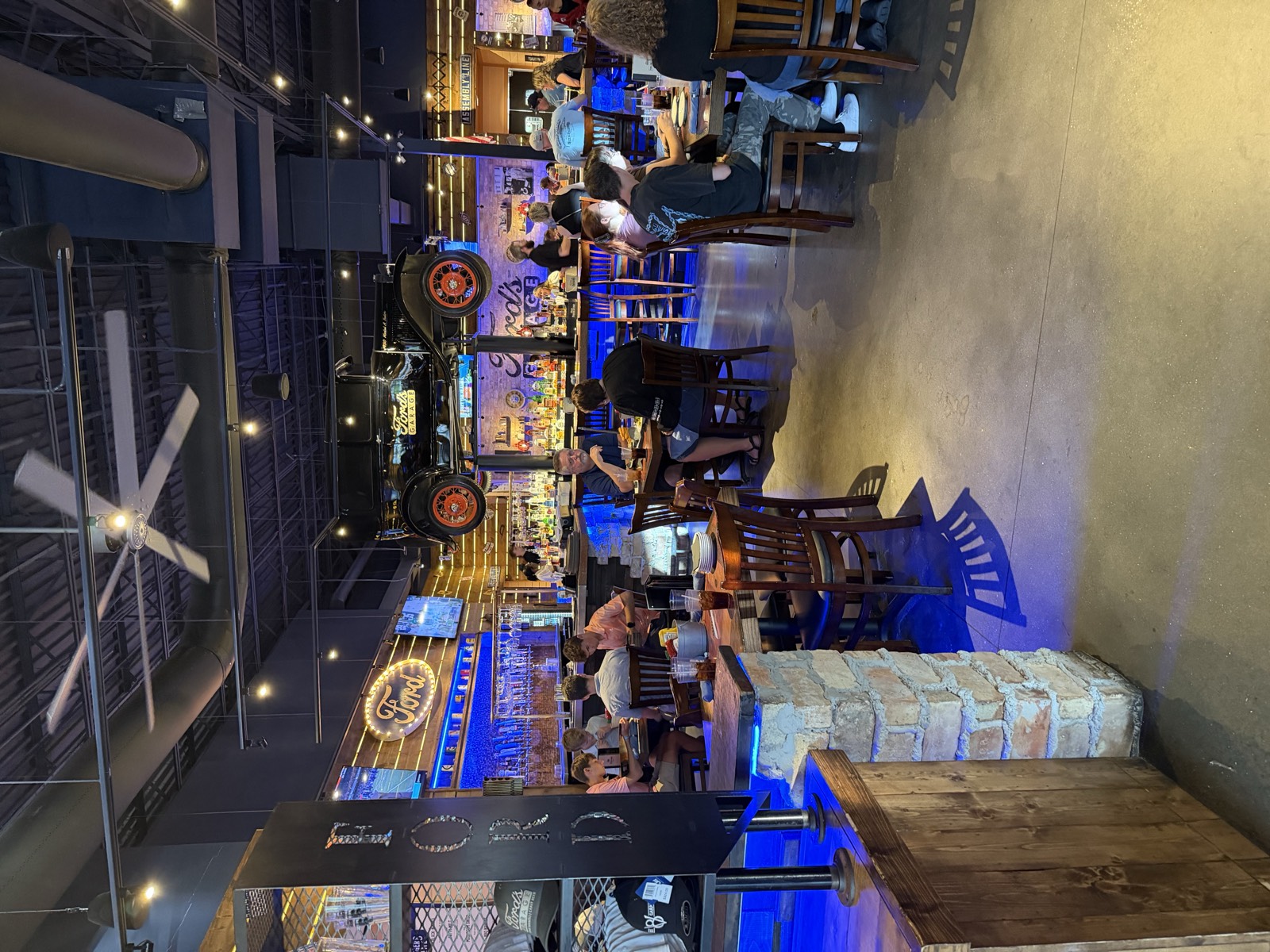 Dining room at Ford's Garage Panama City Beach, with the blue-lit bar in the back