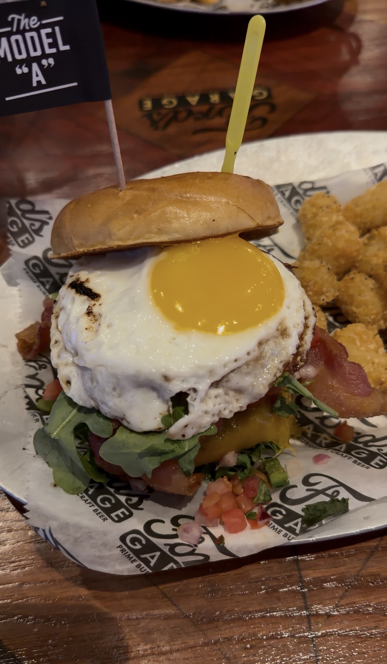 Sam's order: the Model A burger with a fried egg, bacon, arugula, cheddar and pico, with tots, Ford's Garage