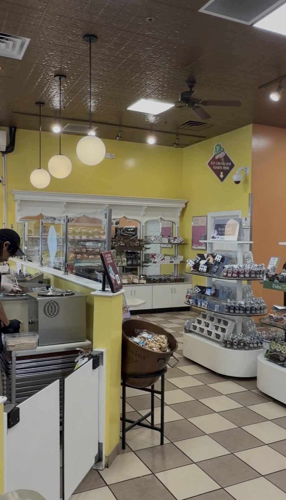 Inside Kilwins, with the ice cream counter, a copper fudge kettle and shelves of chocolates