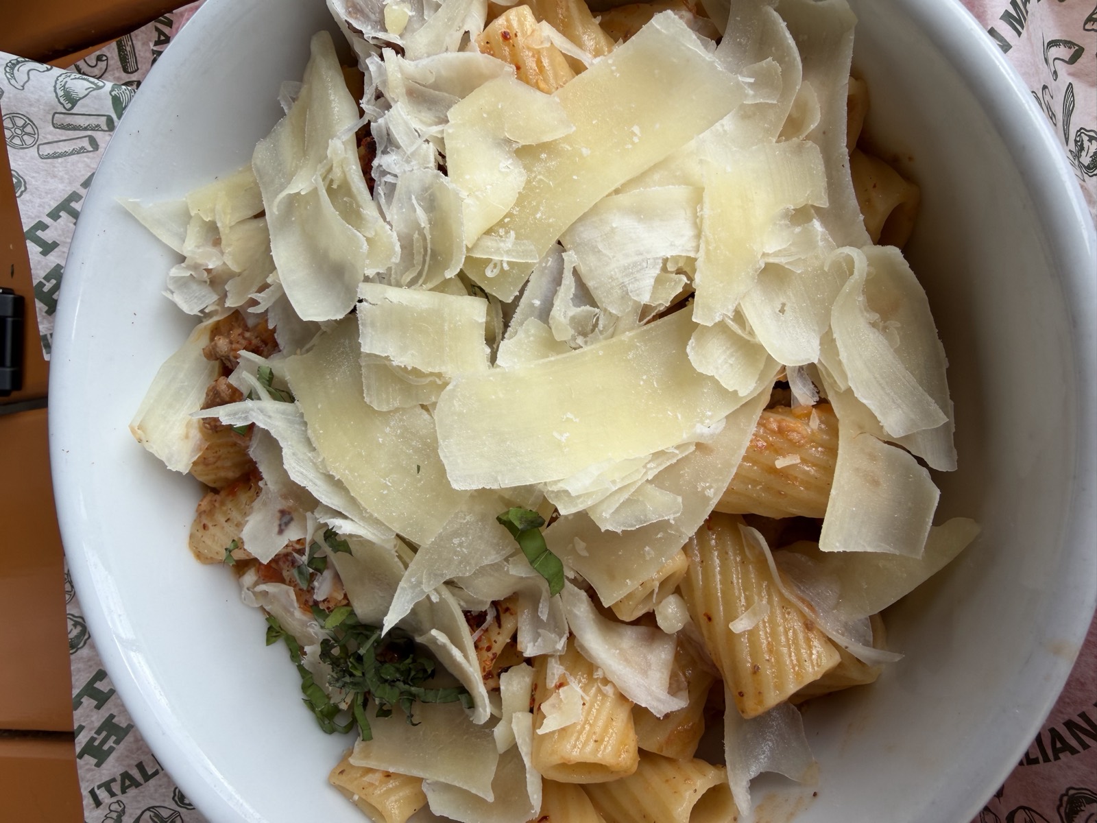 Sam's order: Bolognese & Rigatoni under a pile of shaved parmesan and basil