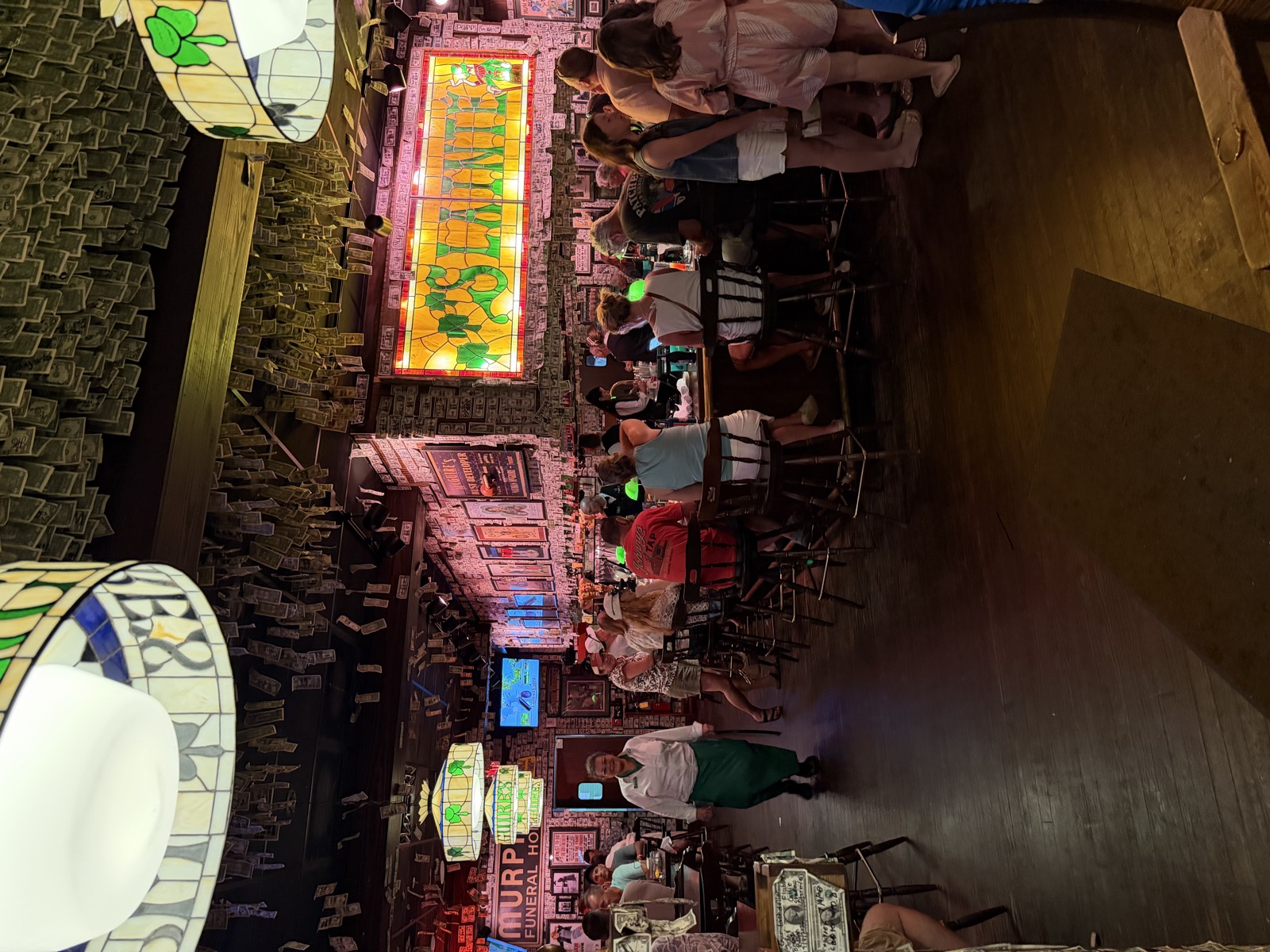The bar at McGuire's Irish Pub, with signed dollar bills covering the ceiling and walls and a Sláinte stained glass sign