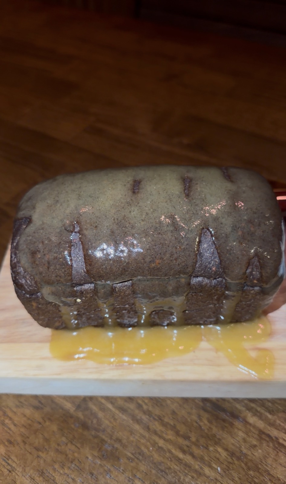 A dark loaf of bread with melted butter poured over it on a wooden board, McGuire's Irish Pub