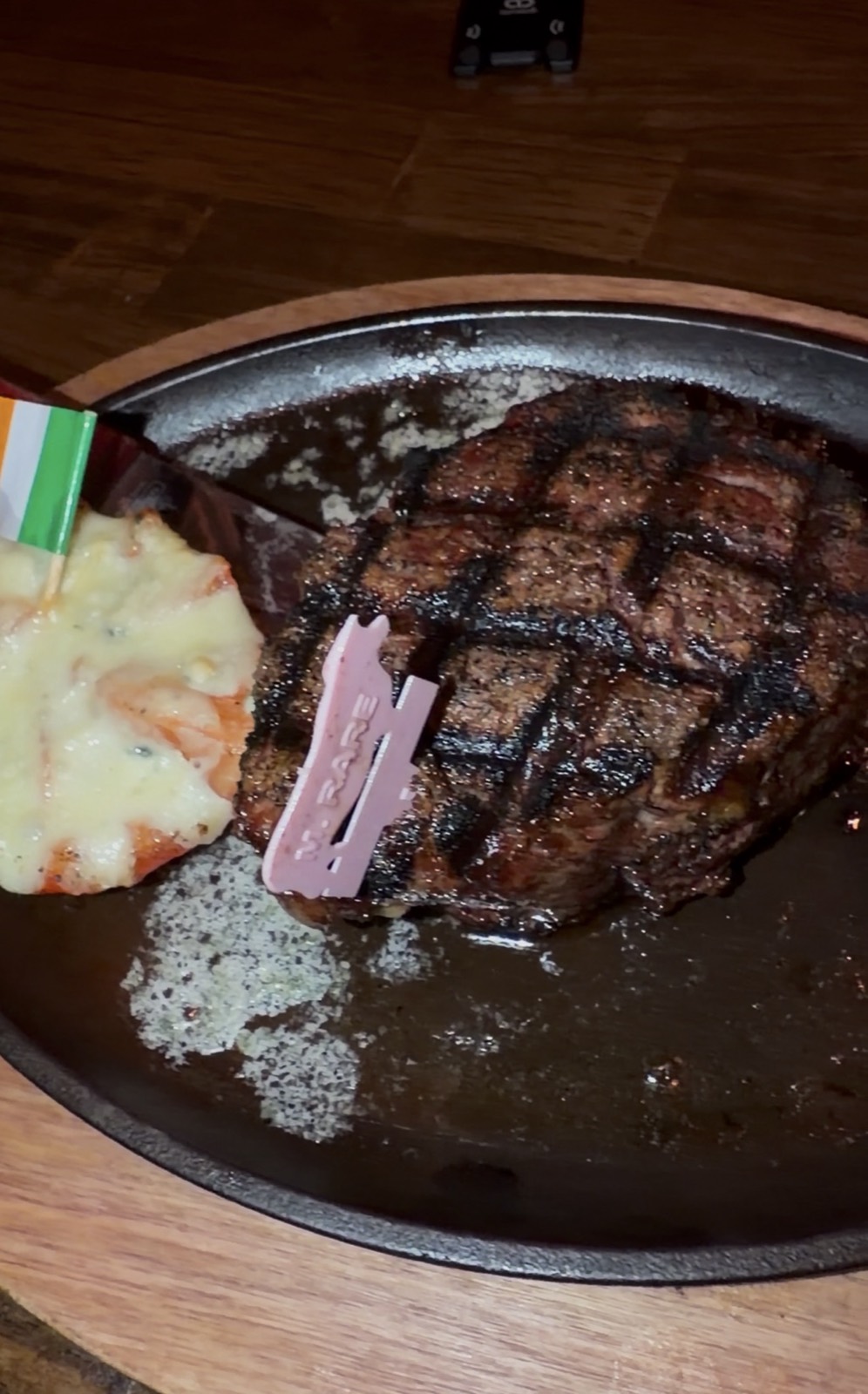 Sam's order: a grilled Filet Mignon on a cast iron plate with a medium rare marker and an Irish flag in the potatoes, McGuire's Irish Pub