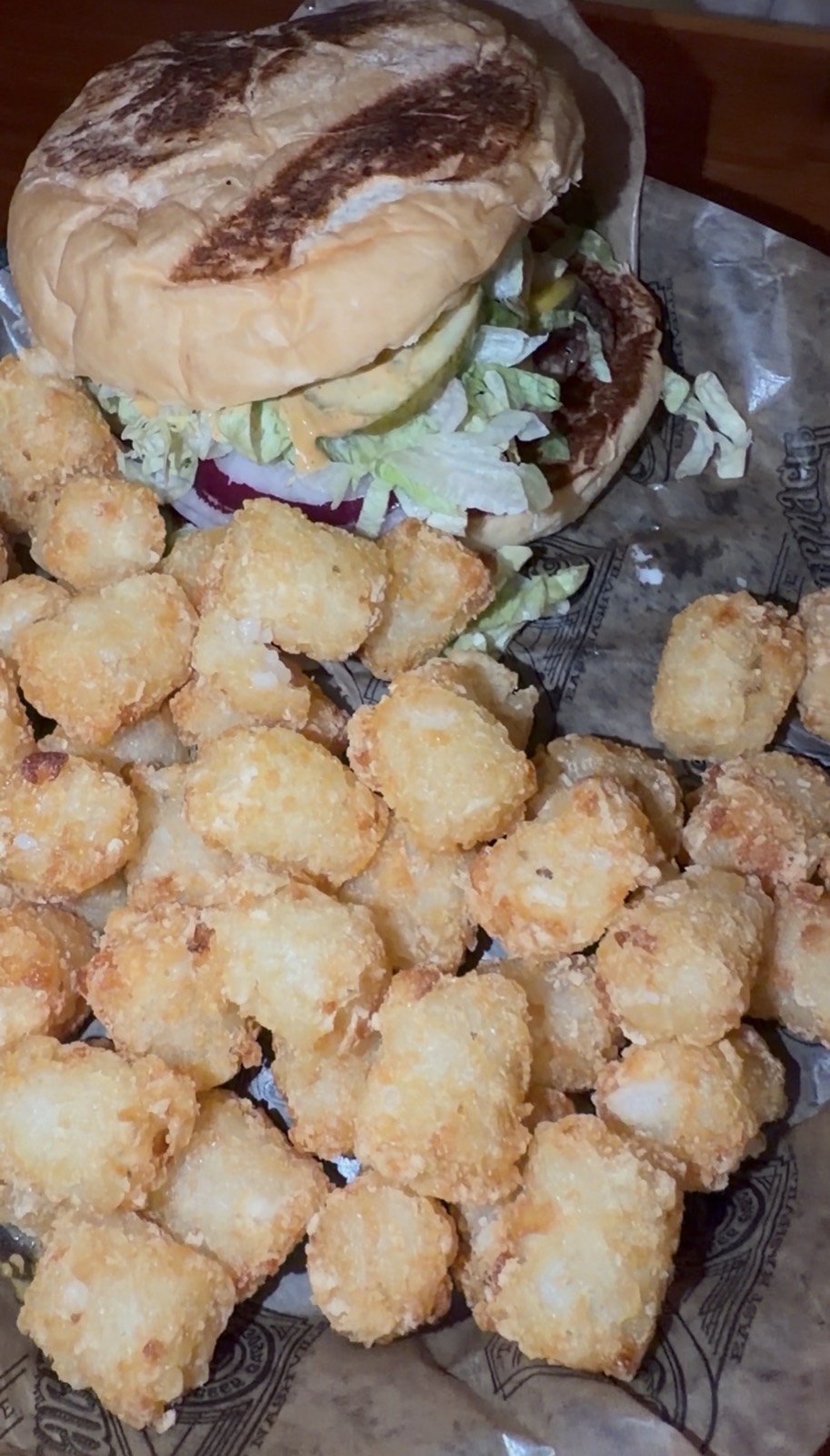 Sam's order: the Pharmacy Burger with lettuce, pickles and onion, served with a basket of tots