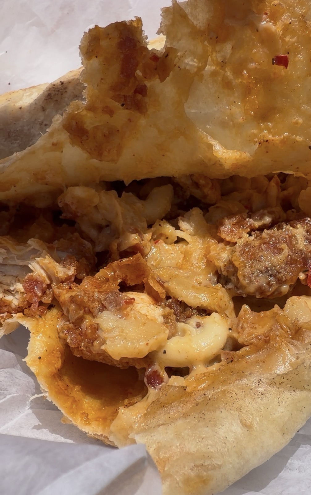 Close-up cross-section of the Hot Chicken Mac & Cheese Crunch Wrap, Red's Hot Chicken