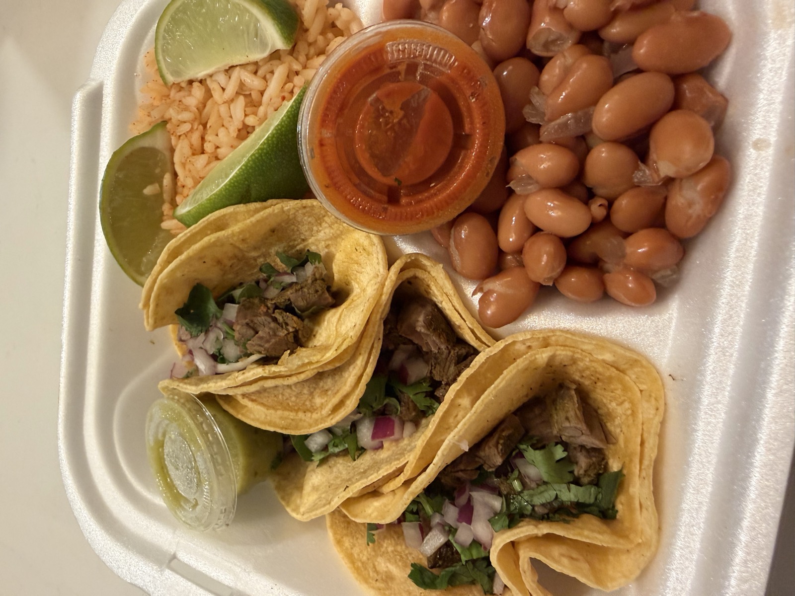 Sam's order: the Steak Taco Plate with three street tacos, rice and beans in a takeout container