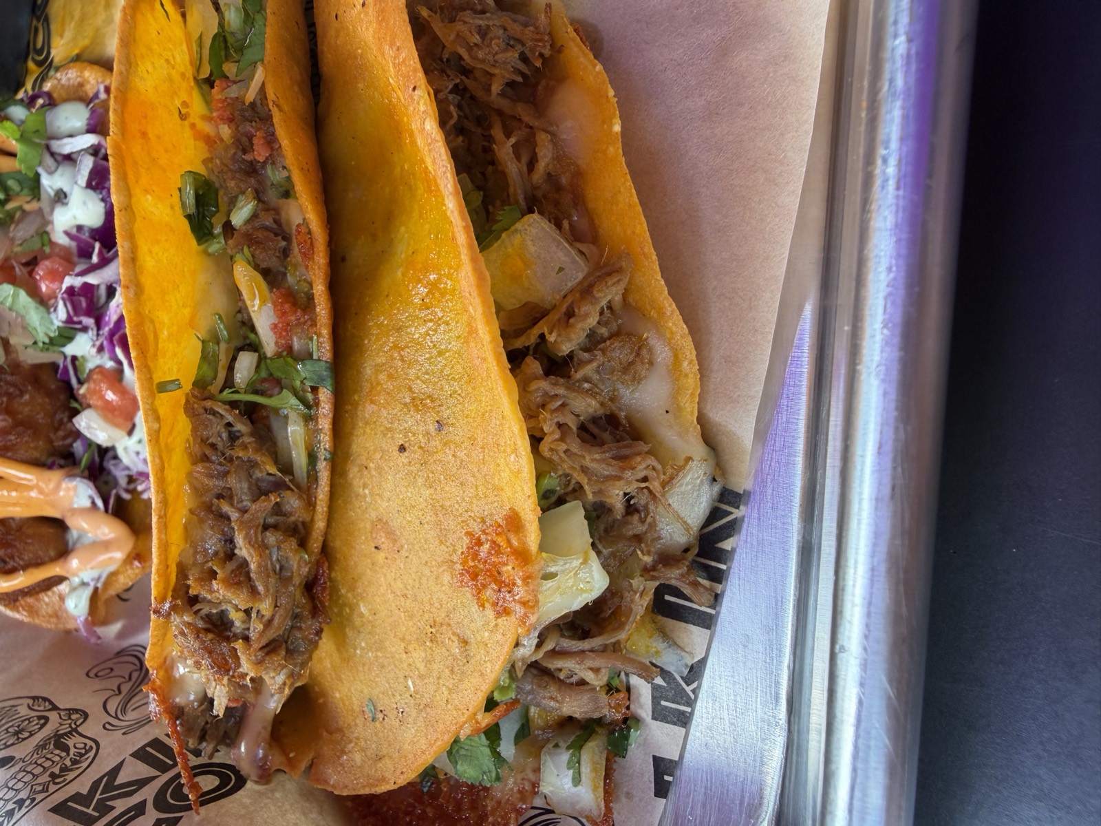 Sam's order: the birria tacos, shredded beef and melted cheese in crisped orange tortillas