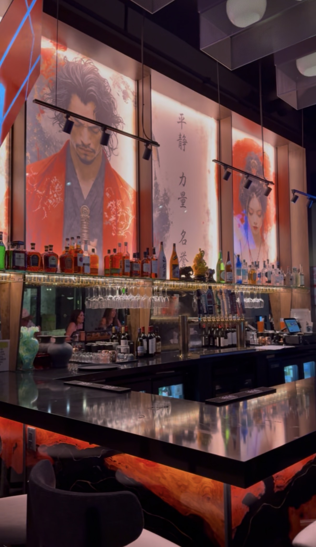 The bar at Thai Samurai River North under backlit samurai murals
