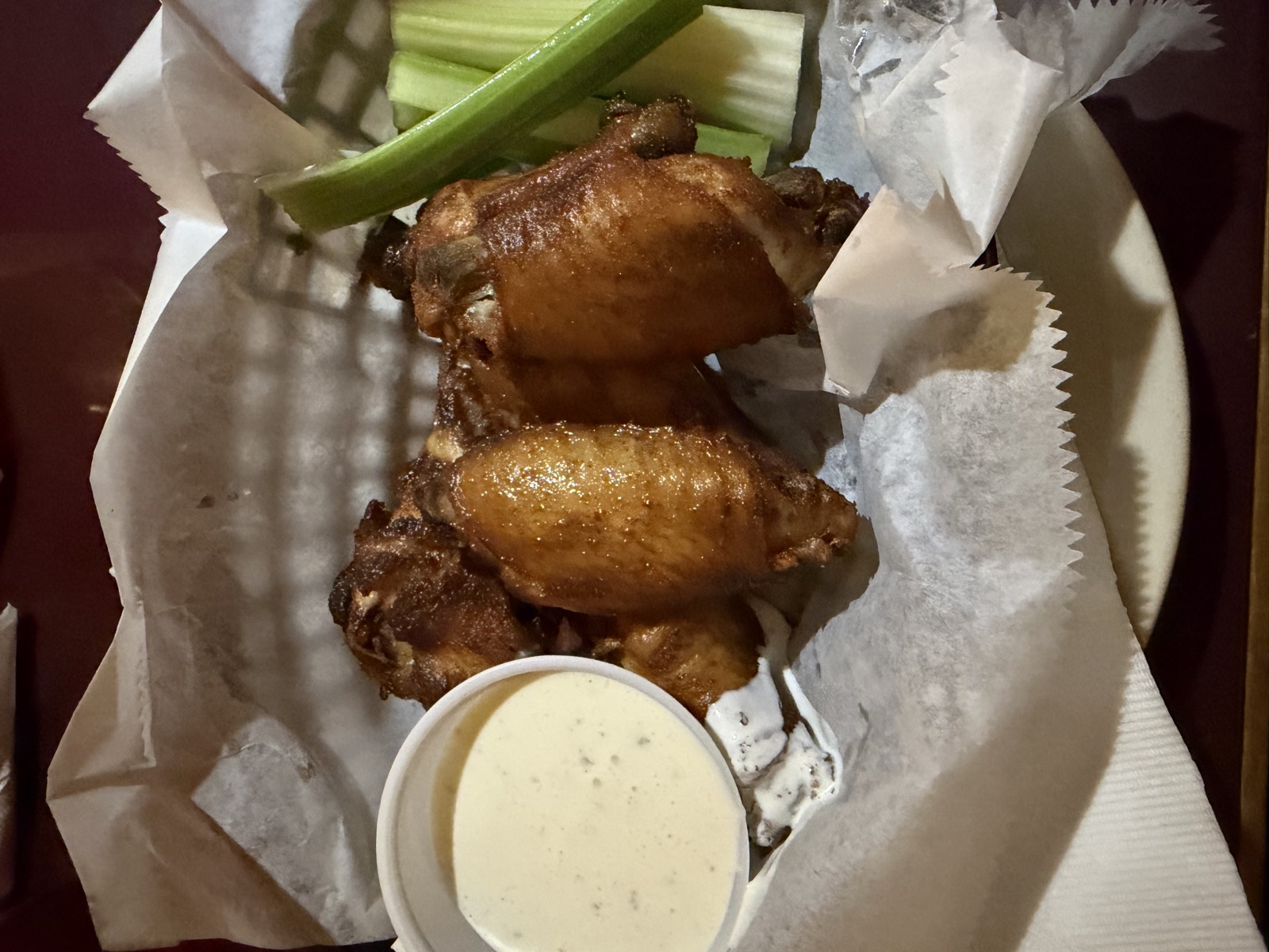 Sam's order: six smoked wings in a basket with celery and a cup of blue cheese